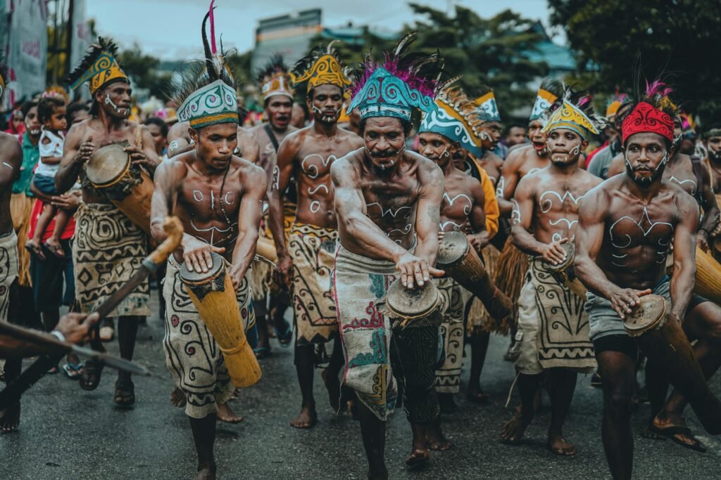 Colorful traditional parade in Papua showcasing dancers in tribal costumes playing drums.